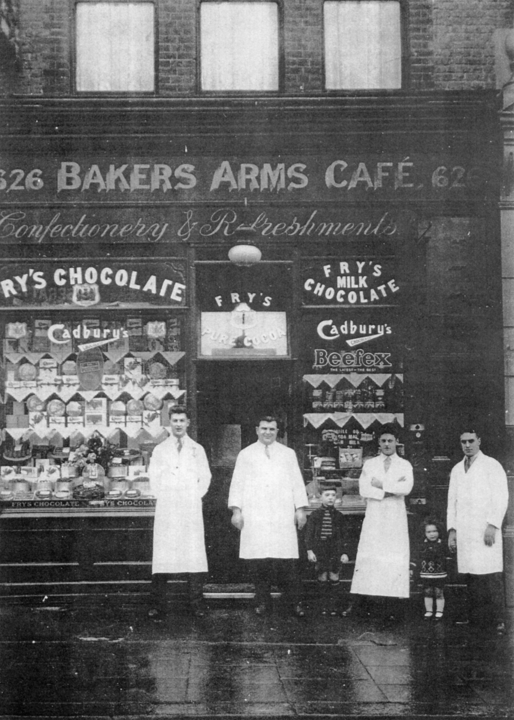 Da dx: Palmiro Ferrari, la figlia Angela, il nipote Antonio, Pacifico con il figlio Giorgio ed un lavorante davanti il Bakers Arms Cafè del 1930 (proprietà Angela Ferrari)